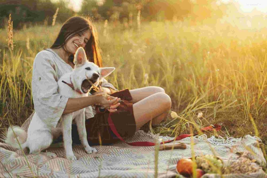 stylish happy woman playing with her white dog with herb on blank